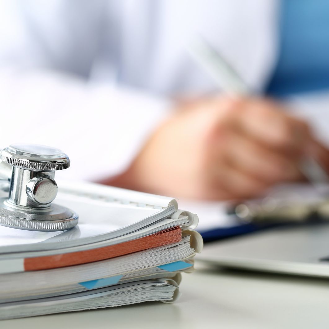 A closeup of a stethoscope on a stack of notebooks